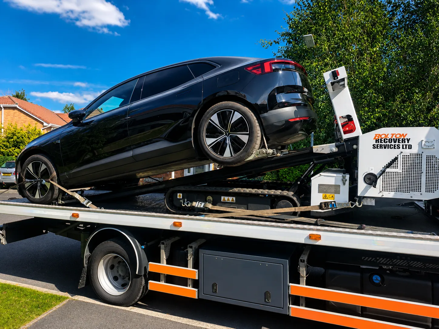 Car recovery in Bolton — vehicle being loaded onto a flatbed recovery truck