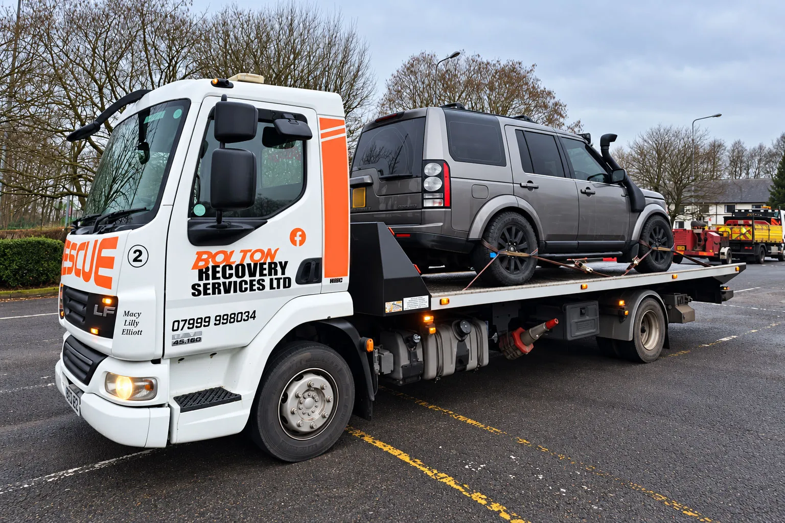 Bolton Recovery Services flatbed tow truck transporting a Land Rover in Bolton